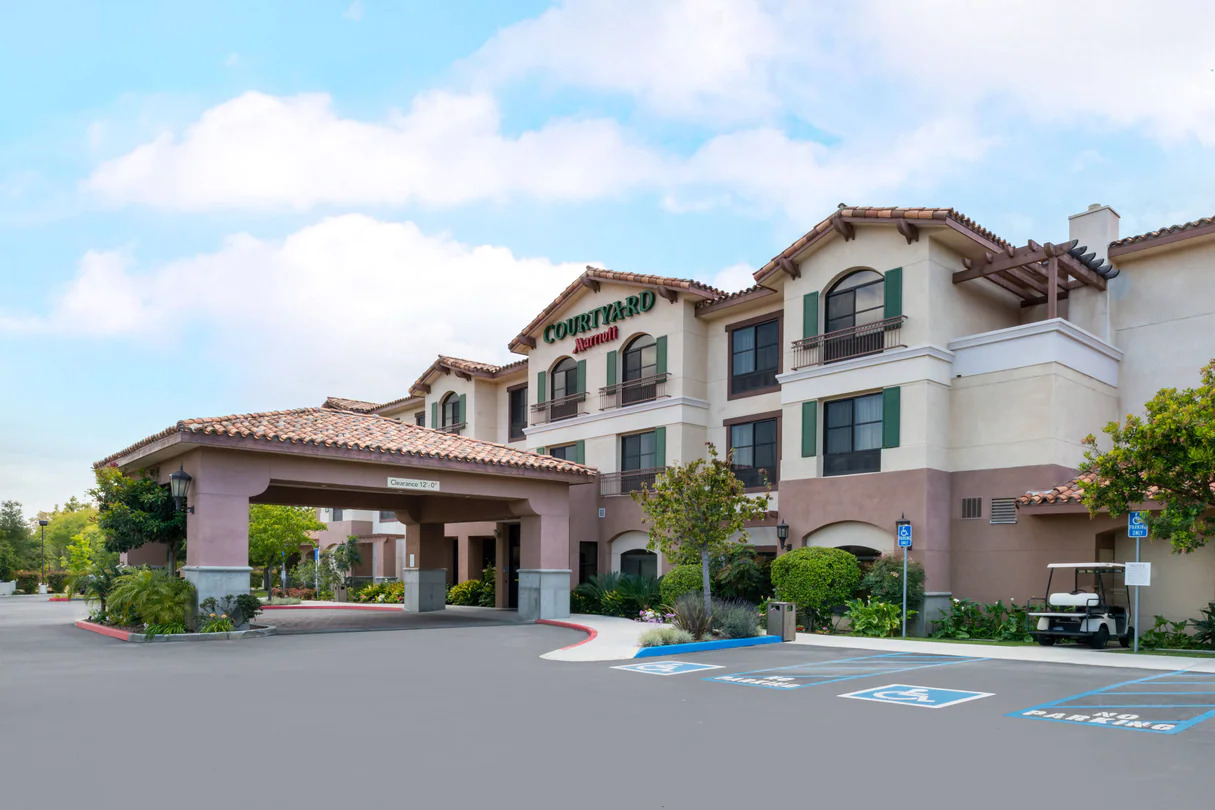 Courtyard Marriott hotel entrance with a covered driveway, displaying "Clearance 12'-0"" and "Courtyard Marriott" signage.