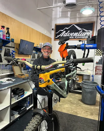 A man works on a mountain bike in a well-equipped repair shop.